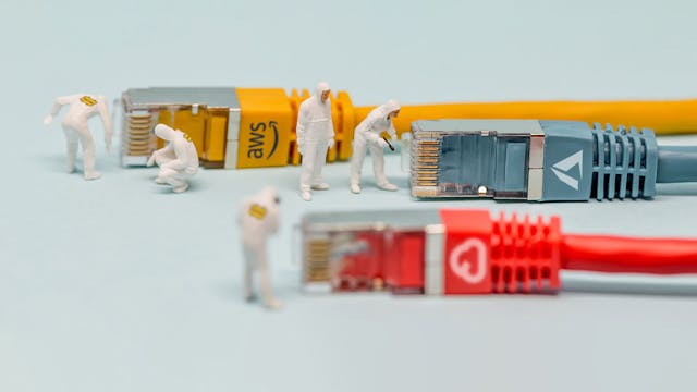 Miniature figures in white clean suits inspecting colorful network cables labeled with AWS, Azure and GCP icons.